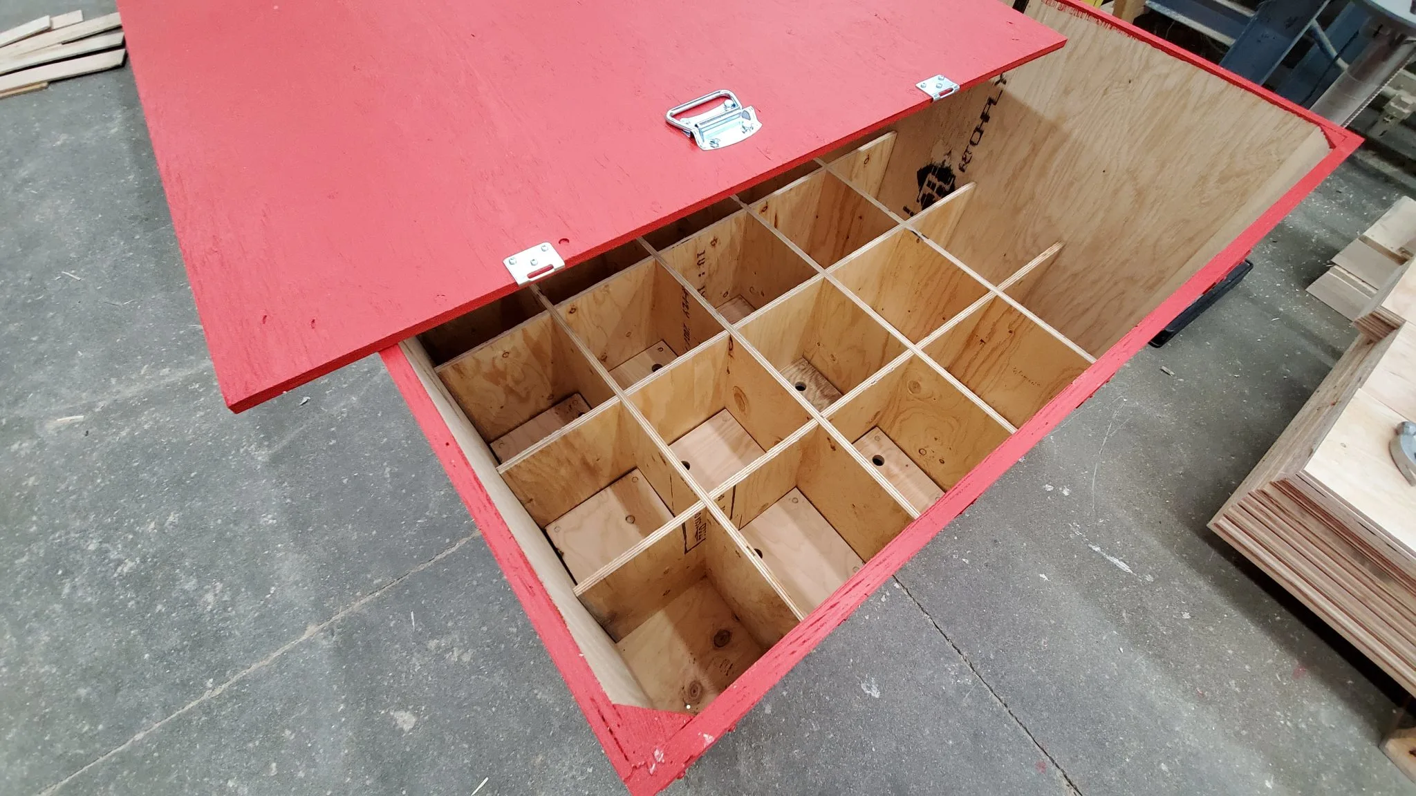 Custom wooden shipping crate with red lid and divided interior compartments, built by 204 Pallet & Packaging in Winnipeg for safe transport of multiple items.